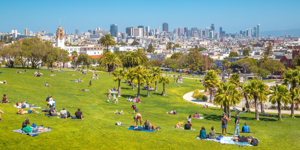 View of San Francisco from Mission Dolores Park with people relaxing