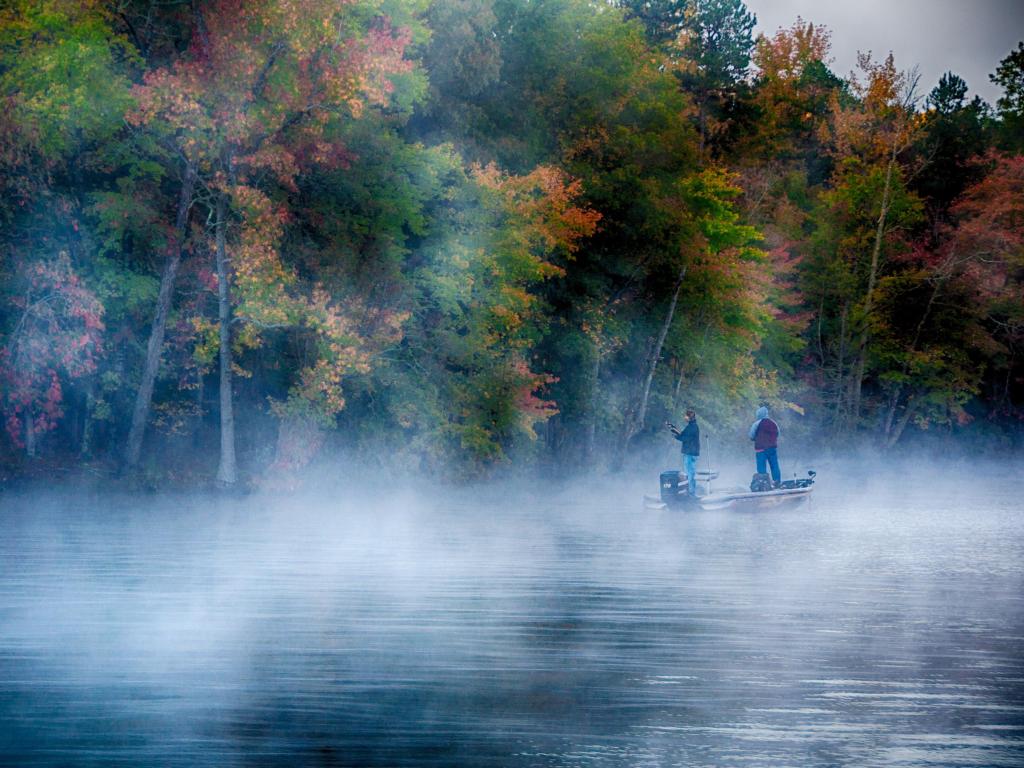 Boat with men fishing on a misty morning at Lake Tillery, NC
