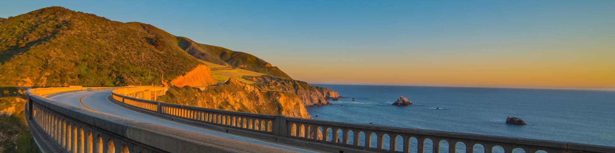 A view from the road running over the Bixby Creek Bridge on the Pacific Coast Highway in California near Big Sur at sunset 