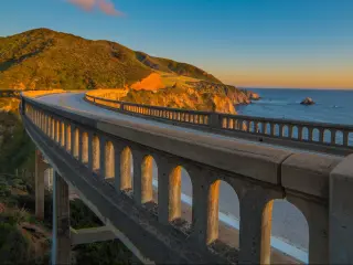 A view from the road running over the Bixby Creek Bridge on the Pacific Coast Highway in California near Big Sur at sunset 