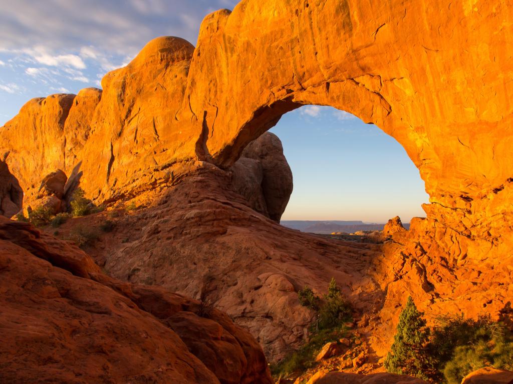 Arches National Park, Utah, USA with a horizontal view of stunning large red sandstone monument with huge window seen at sunrise.