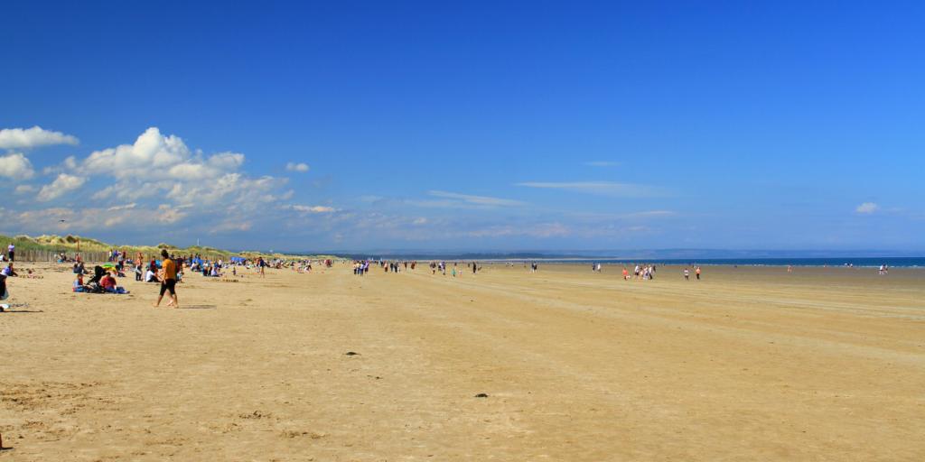 People enjoying St Andrews beach on a sunny day