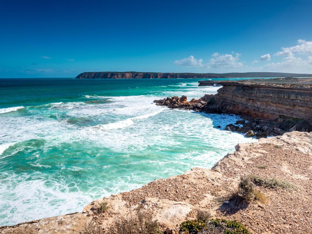 Towering cliffs and surf rolling in from deep blue ocean across Great Australian Bight