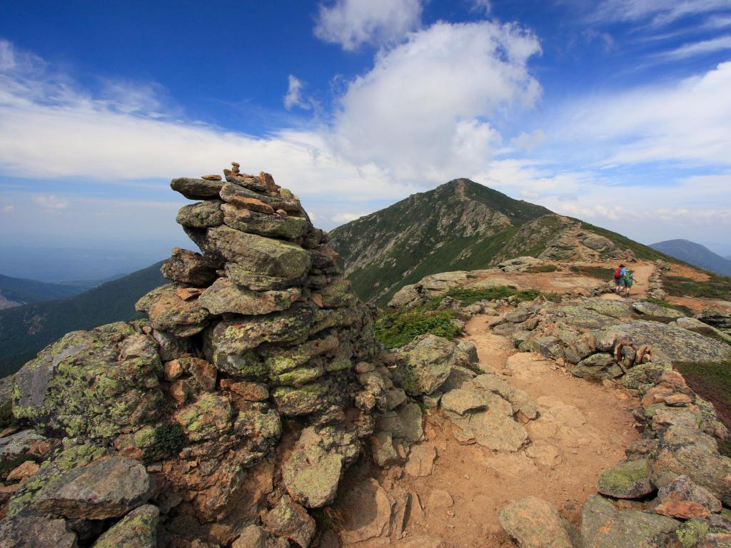 Mount Lafayette, Mount Lincoln, New Hampshire, USA with hikers trekking along Franconia mountain ridge traverse, with a beautiful landscape background and blue sky. 