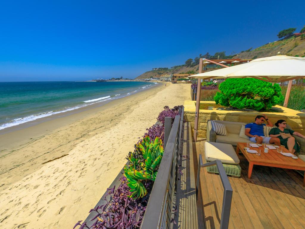 Couple sitting at luxurious Japanese restaurant Nobu along shore of famous Carbon Beach