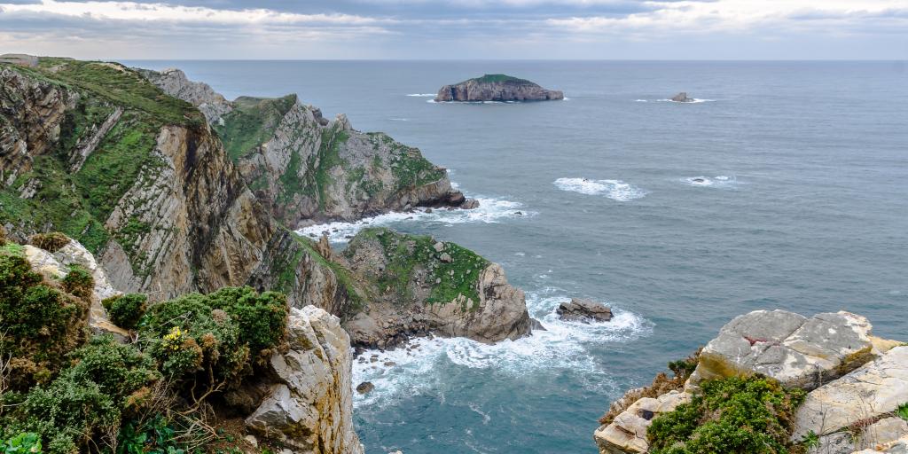 Waves crash against the cliffs of Cabo de Penas in Asturias, Spain