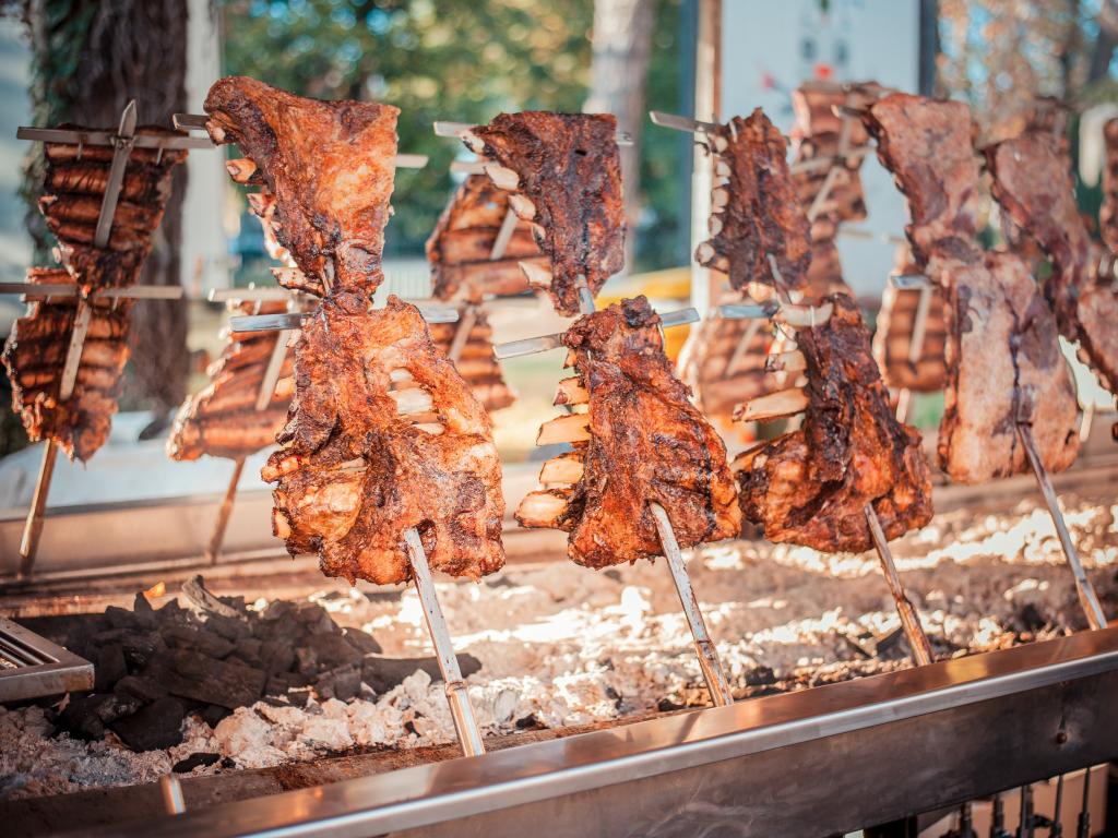 Traditional Argentinian Asado BBQ style cooking large parts of beef and lamb on vertical grills