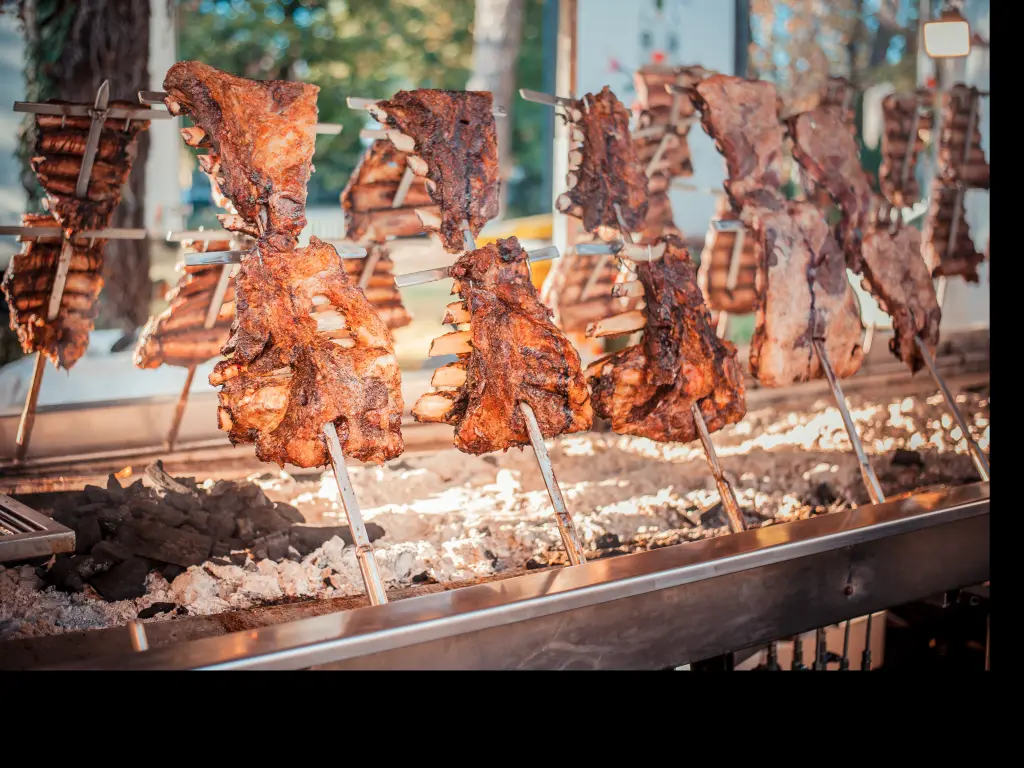 Traditional Argentinian Asado BBQ style cooking large parts of beef and lamb on vertical grills