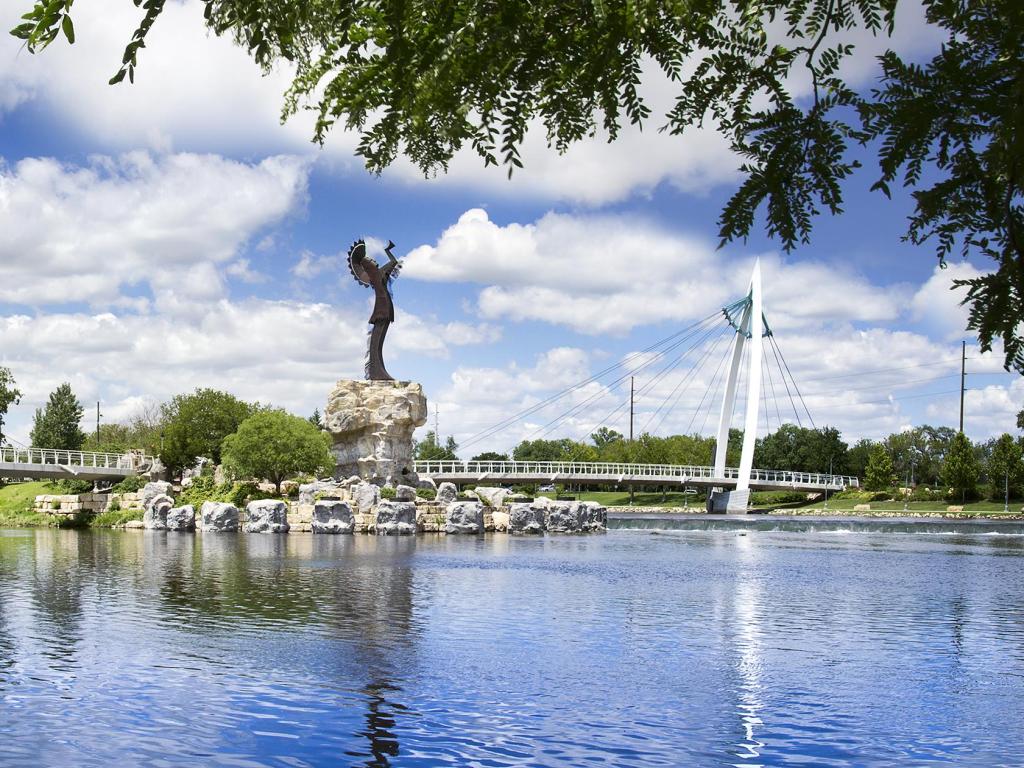 This is a photo of the Keeper Of The Plains statue and foot bridge across the Arkansas River near downtown in Wichita, Kansas.