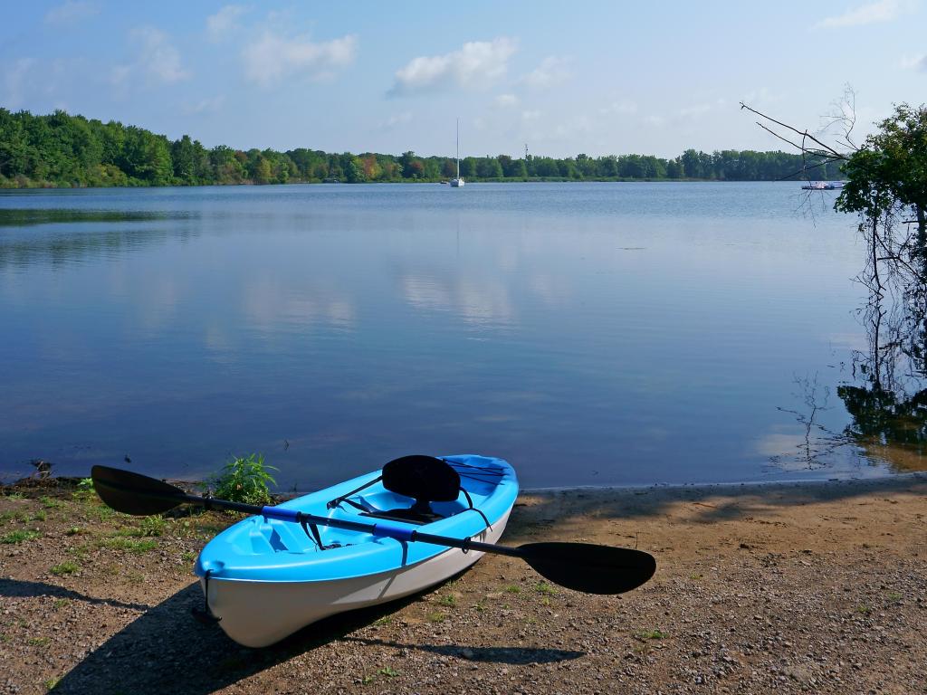 Kayak on beach ready for a summer day paddle, surrounded by blue skies at Lake Erie.