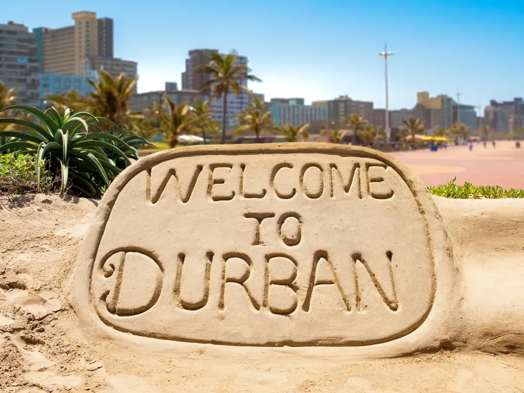 A sign made out of sand the reads "Welcome to Durban"