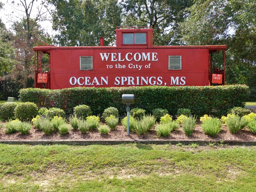View of bright red sign welcoming you to Ocean Springs, Mississippi, United States.