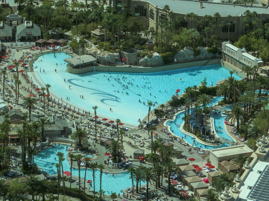 Aerial view of the expansive pool complex at the hotel, surrounded by palm trees