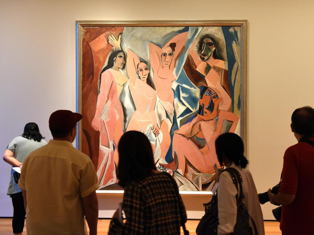 Crowd of people near the Pablo Picasso painting Les Demoiselles D'Avignon in Museum of Modern Art in New York City.