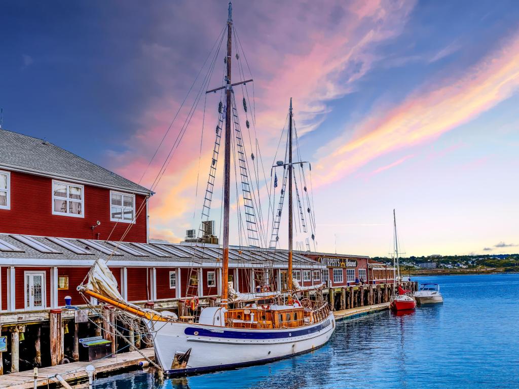 Halifax, Nova Scotia, Canada taken at The Halifax Harbour Walk which is a boardwalk open to the public 24 hours a day at sunset with boats against the jetty.