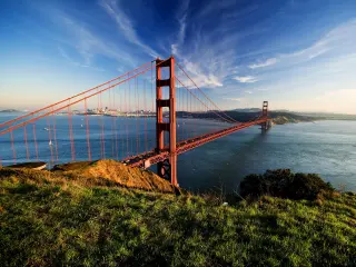 Golden Gate in clear blue sky with green grass as foreground. San Francisco, USA.