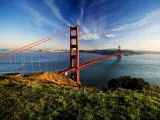 Golden Gate in clear blue sky with green grass as foreground. San Francisco, USA.