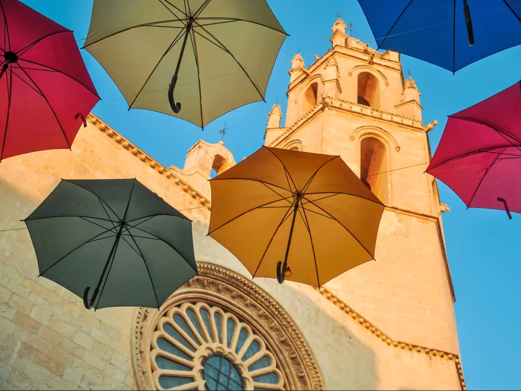 Colorful umbrellas against gothic cathedral of San Pedro in Reus, Spain. Horizontal.
