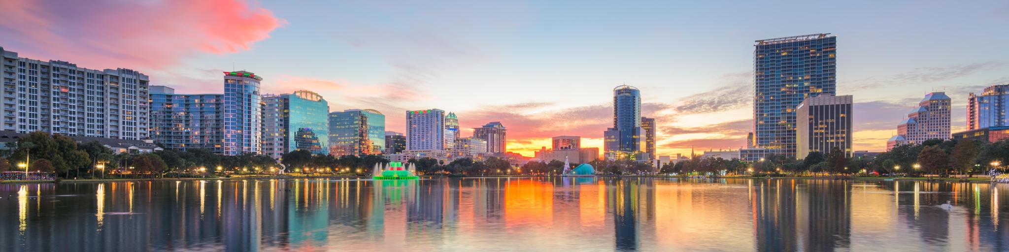 Orlando, Florida, USA downtown city skyline from Eola Park at dusk.