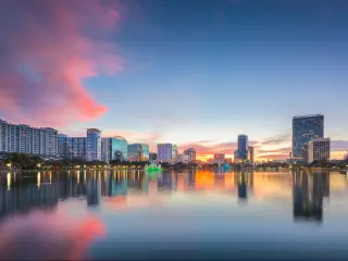 Orlando, Florida, USA downtown city skyline from Eola Park at dusk.
