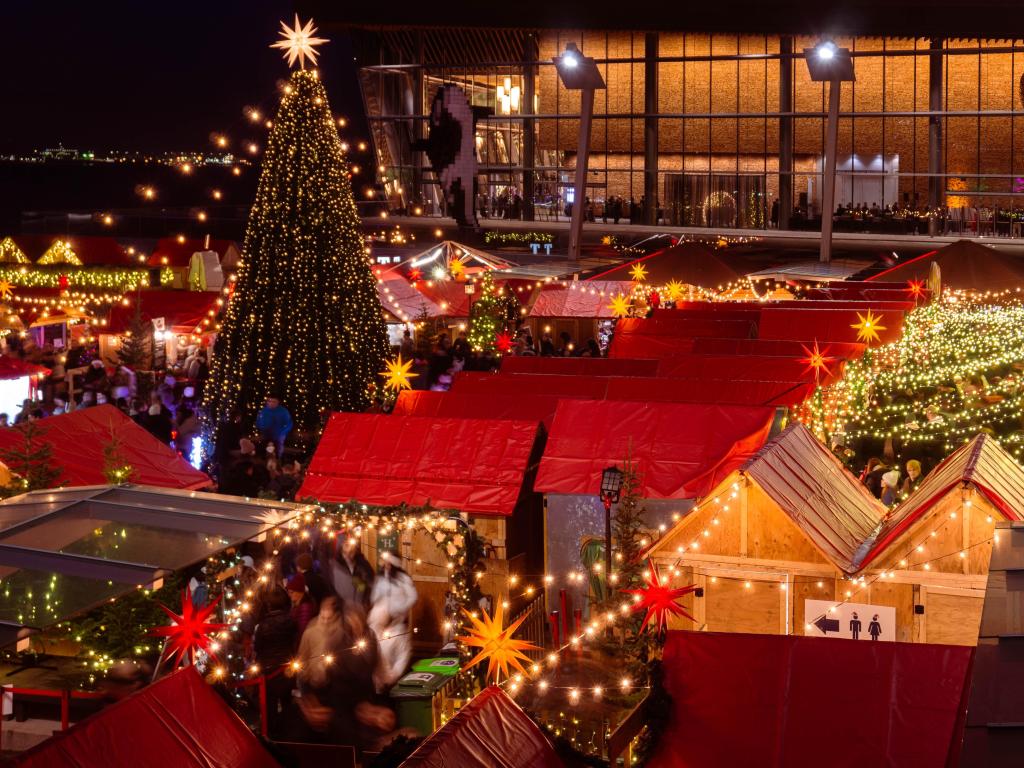 Beautiful lit-up Christmas Market with red tents and a Christmas tree