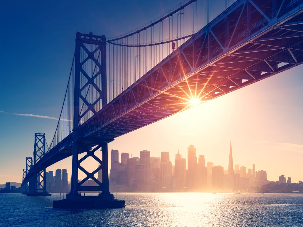 San Francisco skyline behind the Bay Bridge at sunset