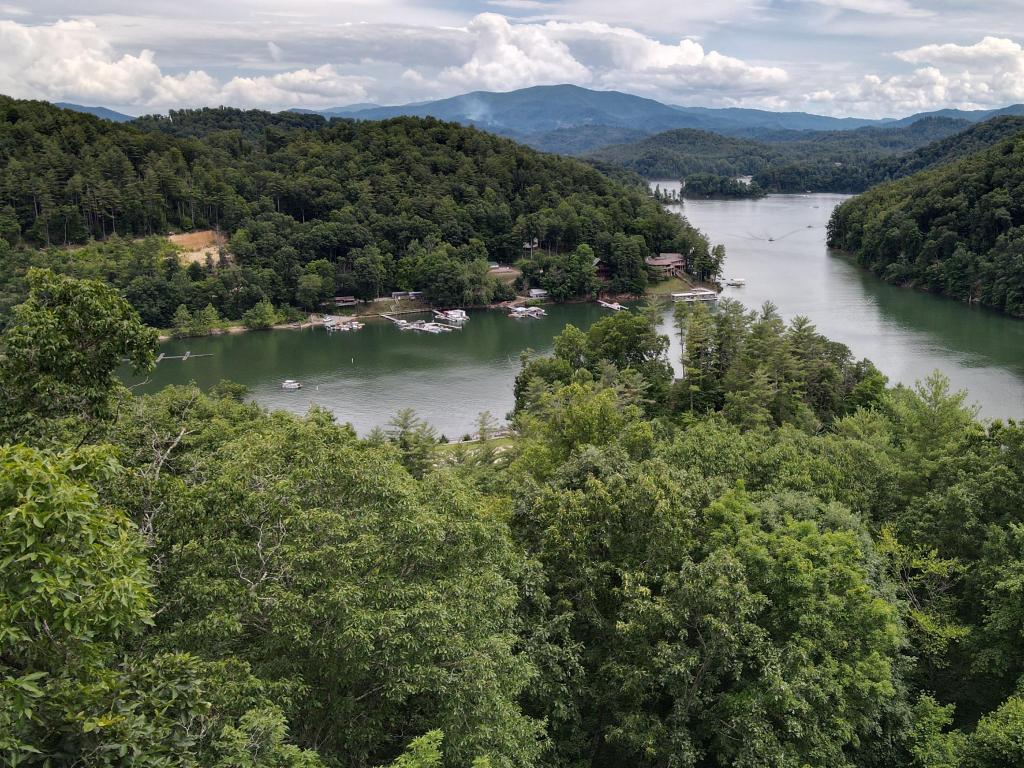 Watauga Lake with misty, forested mountains all around and small jetties dotting the shoreline