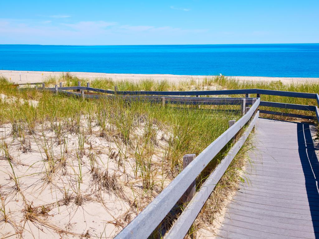 Sandy Neck Beach, Massachusetts, USA taken at Cape Cod in Barnstable with a boardwalk through the sand dunes and the sea in the distance. 