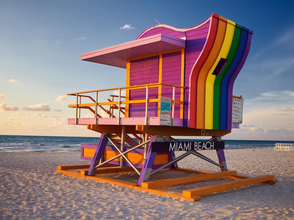 Vibrant, rainbow-colored Lifeguard Hut on the beach at 12th Street, Miami Beach, with the sea in the background