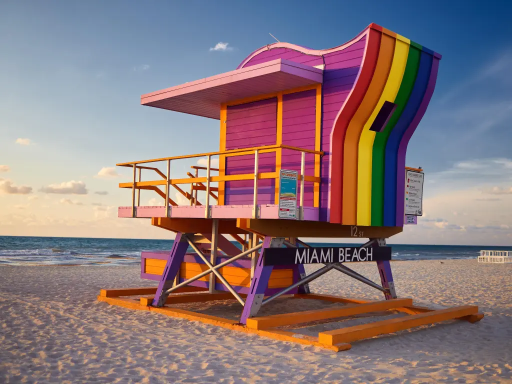 Vibrant, rainbow-colored Lifeguard Hut on the beach at 12th Street, Miami Beach, with the sea in the background
