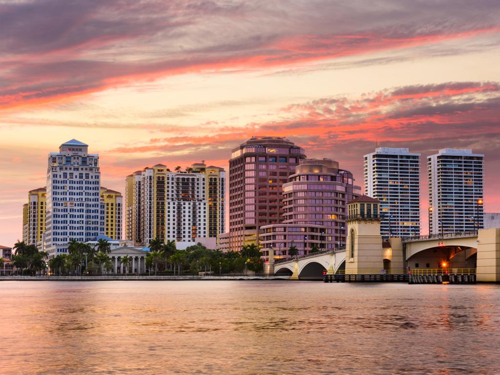 West Palm Beach, Florida skyline in the background with the Intracoastal Waterway in the foreground at sunset.