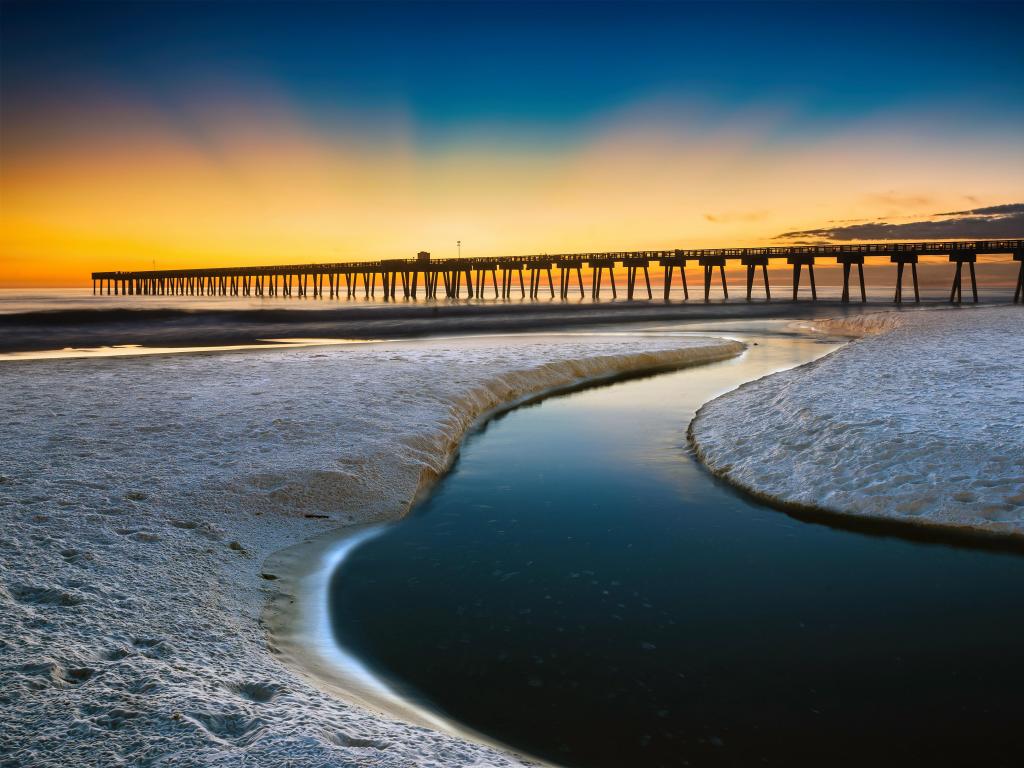 Panama City Beach, Florida, USA with a beach scene taken after sunset and the pier in the distance.