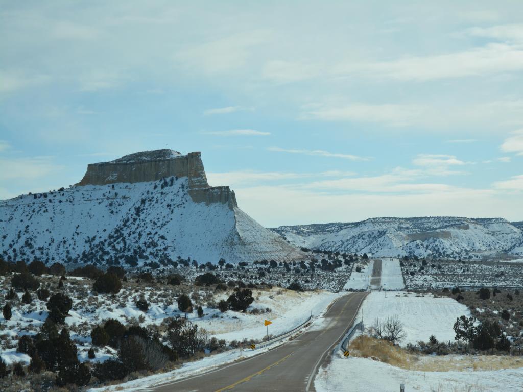 Road through Grand Staircase Escalante National Monumnet in winter with snow covering the surroundings
