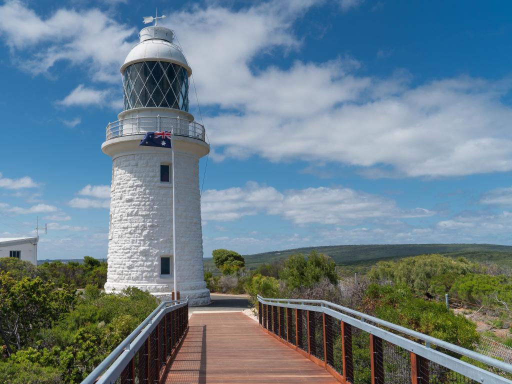 Historic lighthouse on Cape Naturaliste in Western Australia with blue skies and partial clouds.