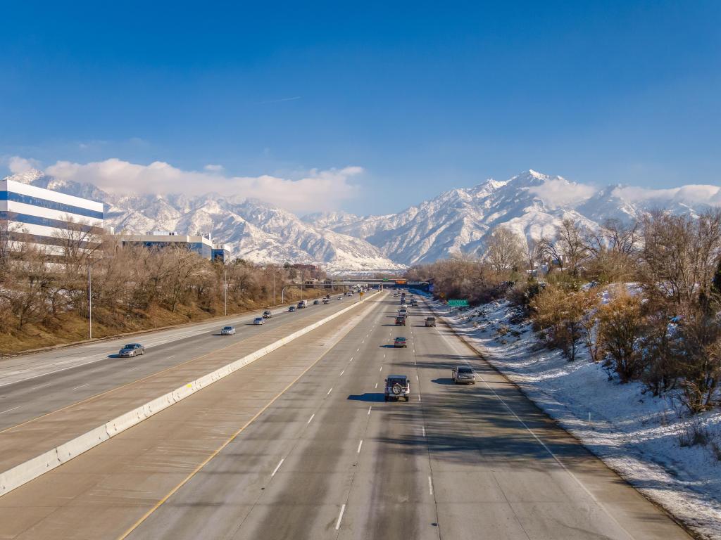 View of highway in Salt Lake City with snow-covered mountains in background.