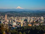 Cityscape of Portland, Oregon and Mount Hood towering in distance, autumn afternoon.