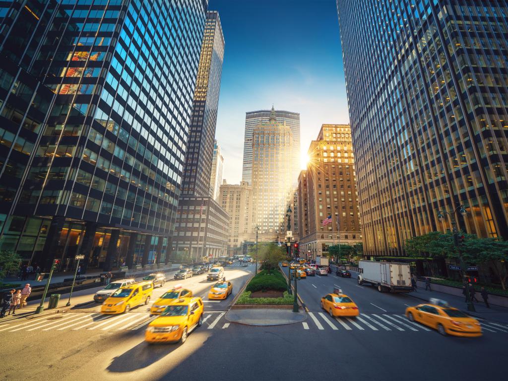 View from Park Avenue in Manhattan, New York City.  View of Grand Central with a blue sky above and yellow taxis on the road 