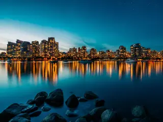 Skyline of the city just before sunset, building lights are reflected on the water