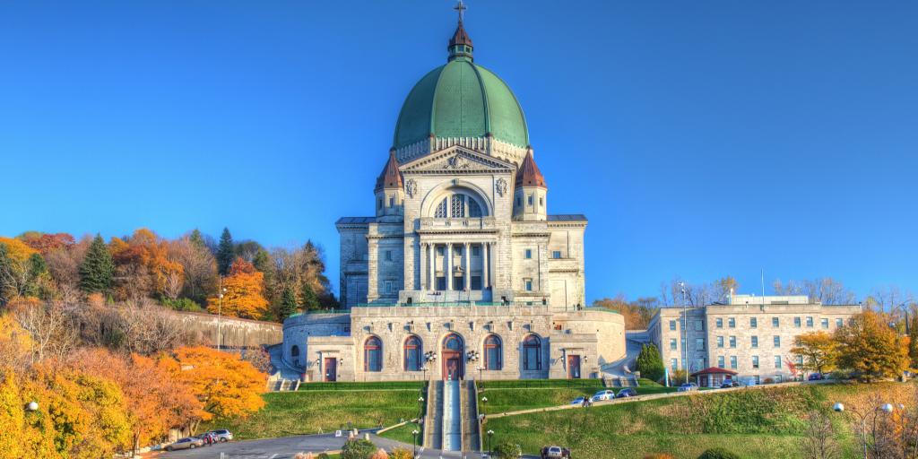 St Joseph's Oratory, Montreal on a hill surrounded by trees and a blue sky 