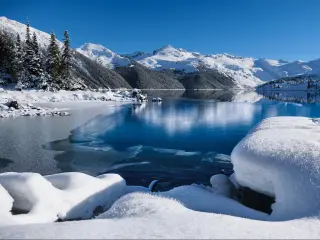 Winter lake with reflections of mountains in calm water. Garibaldi Lake in Whistler. British Columbia. Canada