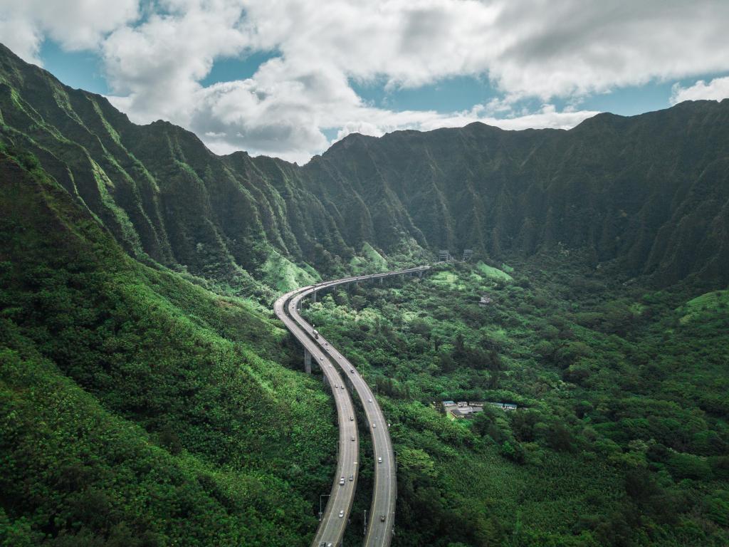 Highway through mountains and forests in Hawaii, cloudy weather