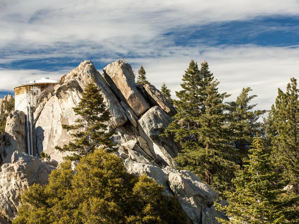 Mountain peaks surrounded by nature with blue skies in the background.