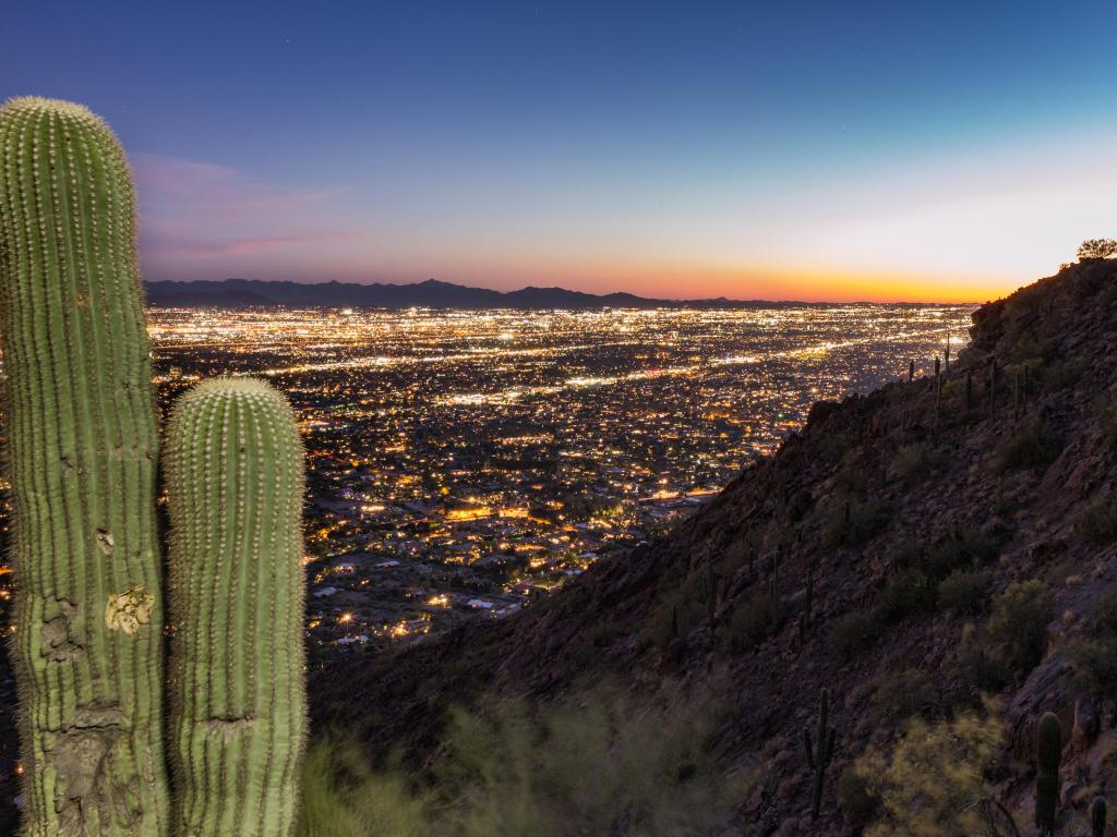 Sun setting over Phoenix, view from the top of the mountain onto the night lights of the city