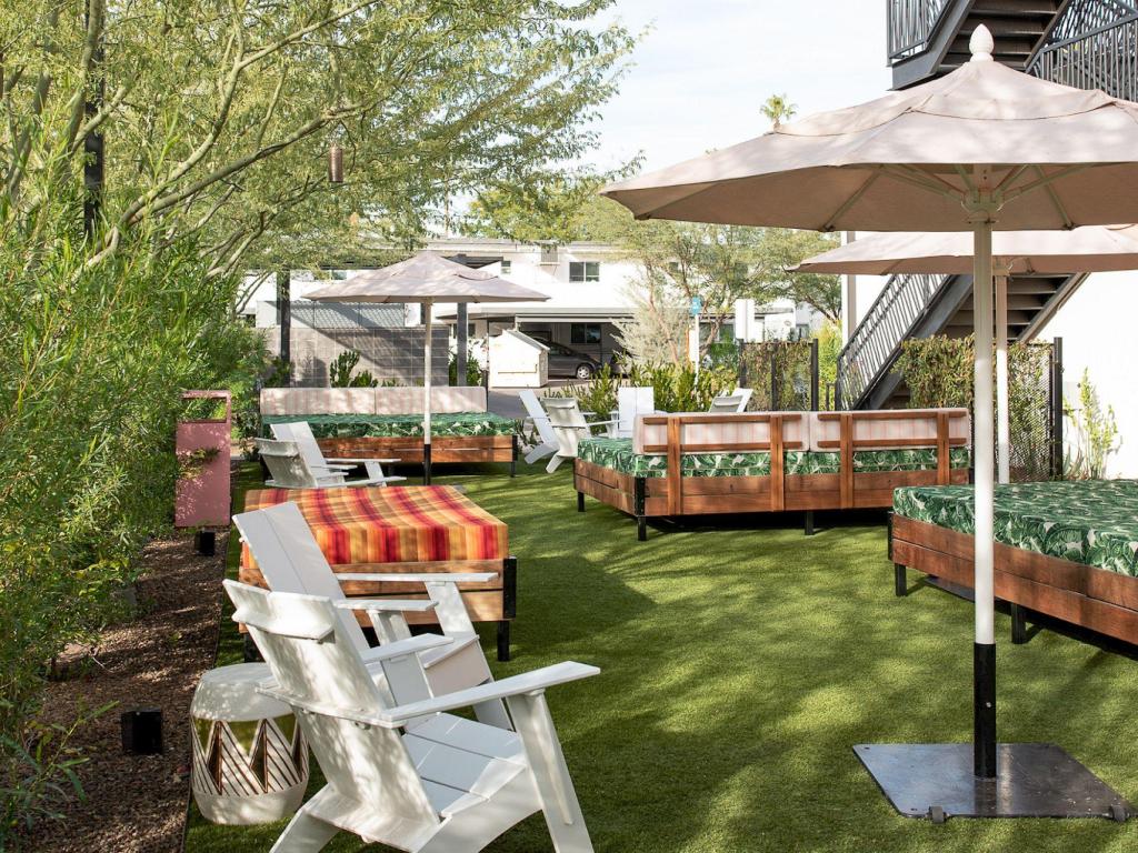 Stylish and chic outdoor terrace with white loungers, chairs and umbrellas at RISE Uptown, Phoenix
