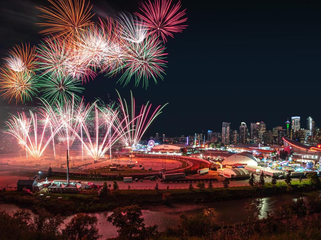 Calgary Stampede, Calgary, Canada with a colorful firework display over the night sky with the Calgary downtown skyline in the backdrop during the annual Calgary Stampede.