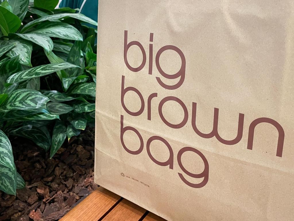 Iconic brown paper Bloomingdale’s bag sits on a bench