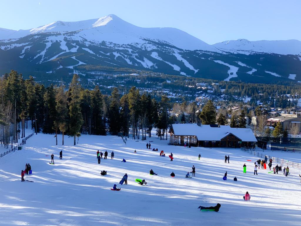 Kids sledding at Carter Park on a snowy hill in Breckenridge, Colorado.