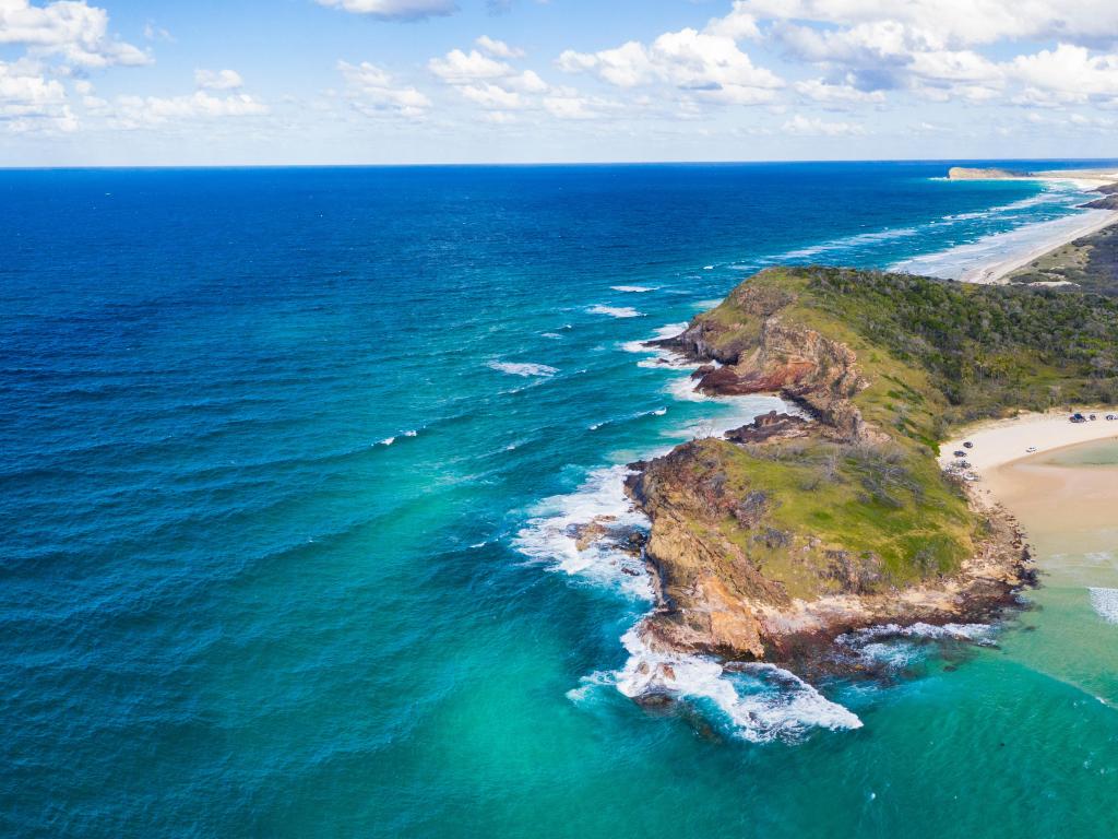 Fraser Island, Queensland an aerial view on the stunning island with ocean surrounding the beach and a blue sky. 