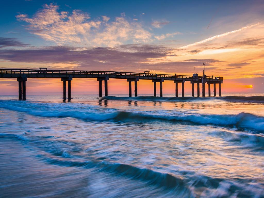 Waves on the Atlantic Ocean and fishing pier at sunrise, St. Augustine Beach, Florida.