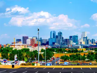A fine day with blue and cloudy sky at Denver Broncos Stadium at Mile High with Downtown Denver in the background